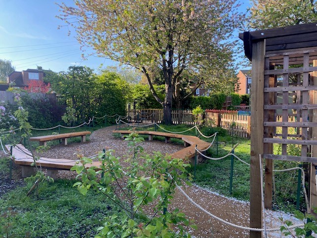 Image of sensory garden, with raised flower beds and trees